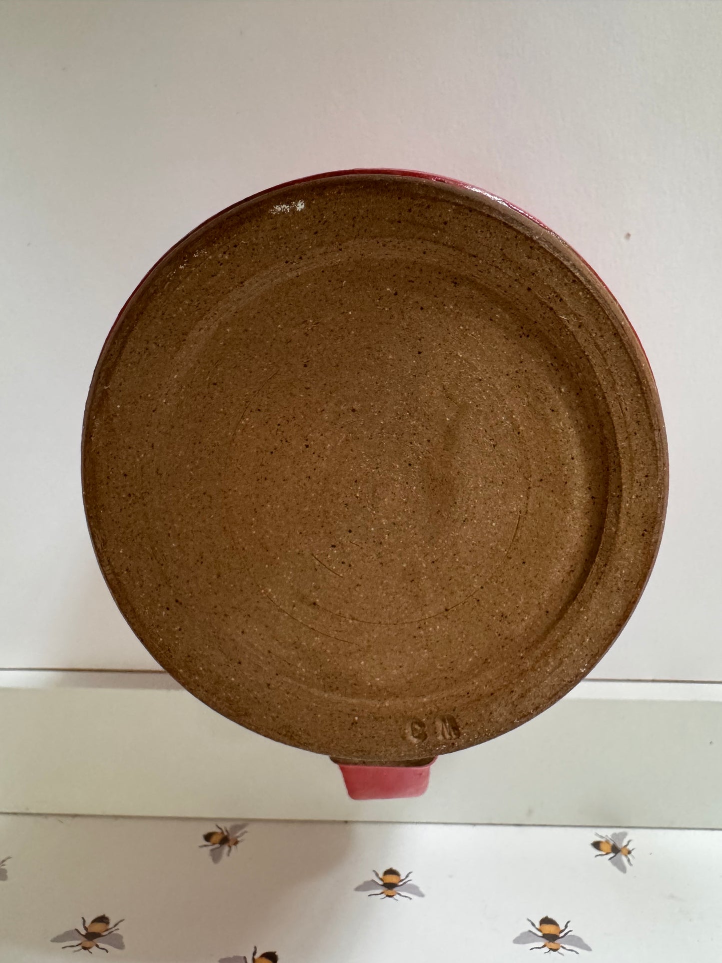 A mug (red matte on dark clay)