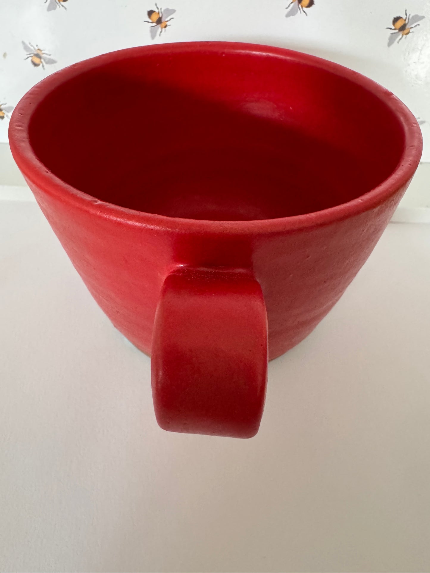 A mug (red matte on dark clay)