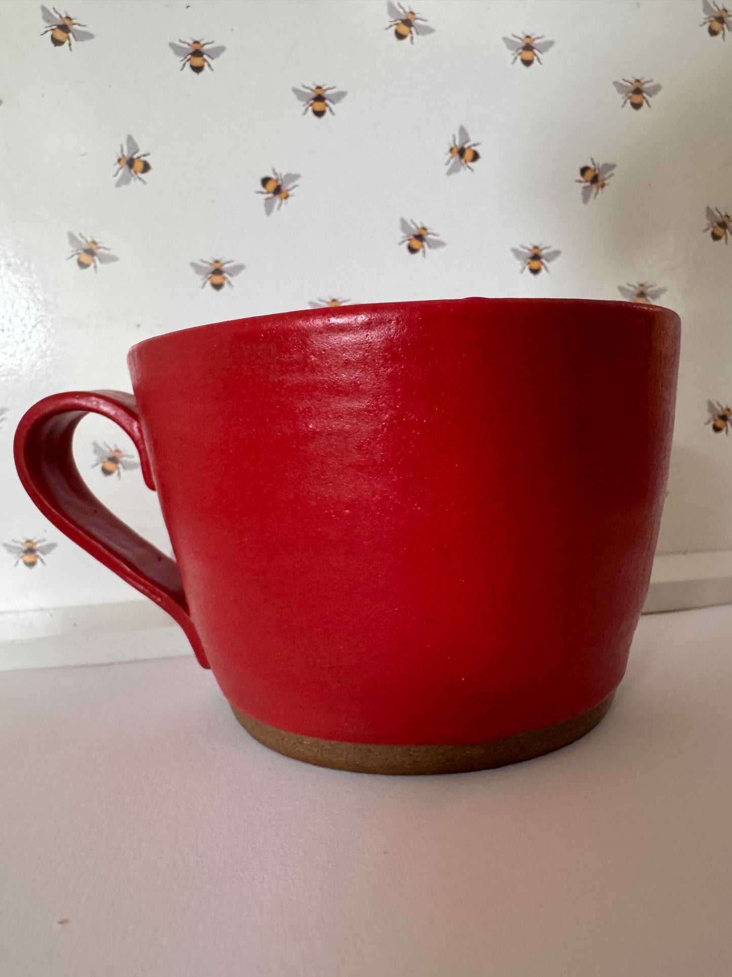 A mug (red matte on dark clay)