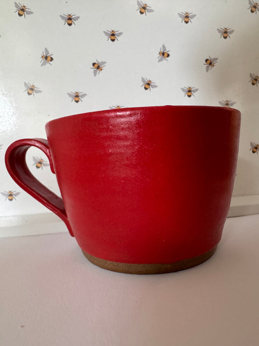 A mug (red matte on dark clay)