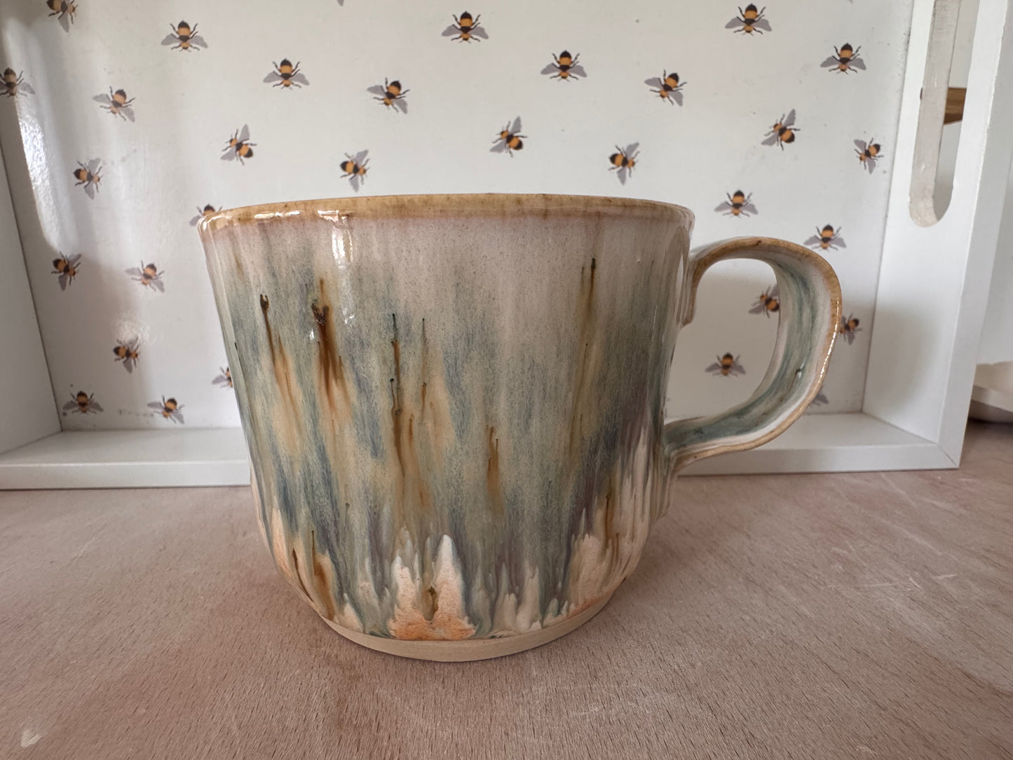 A mug (cream with bluey-purples, squared-off handle)