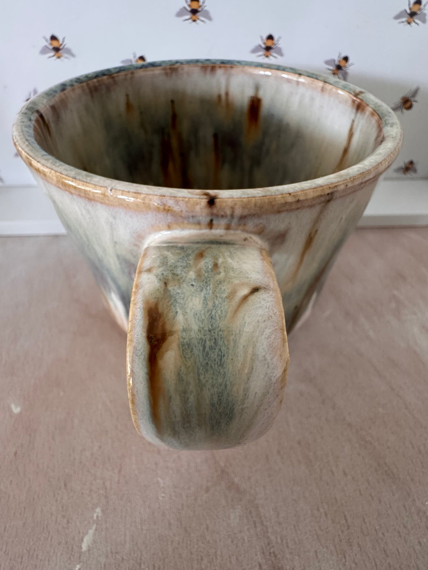 A mug (cream with bluey-purples, squared-off handle)